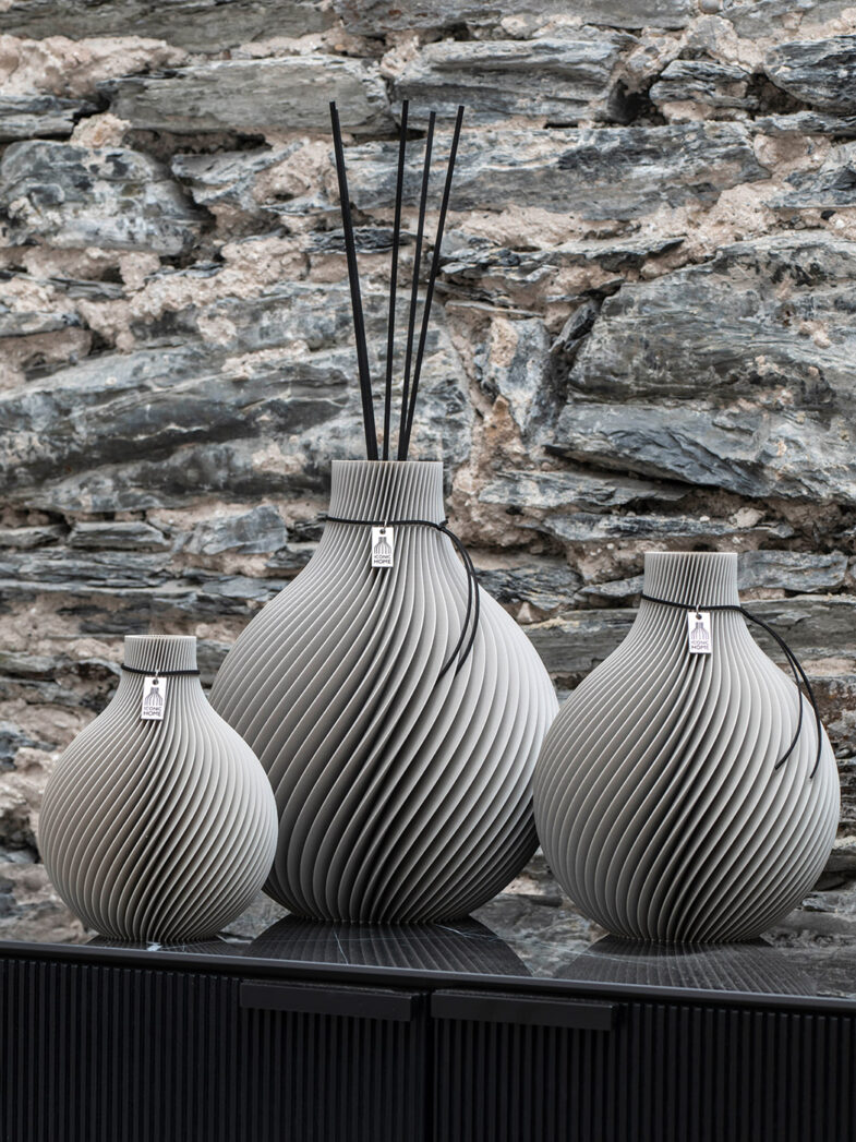 Vaso Sfera Set come grande vaso profumato di fronte a un muro di pietra
